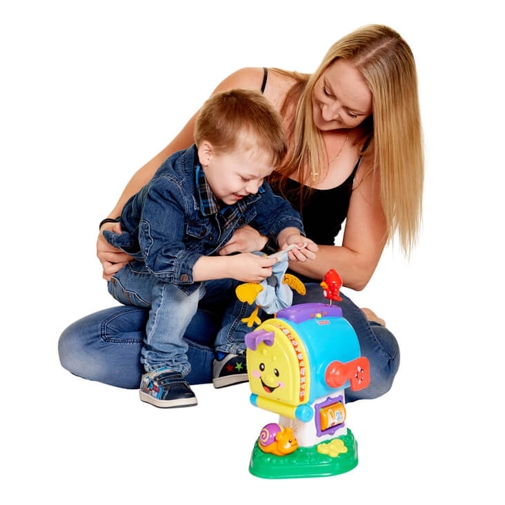 Mother and child seated on the floor playing with a colorful toy mailbox, shown after background removal.