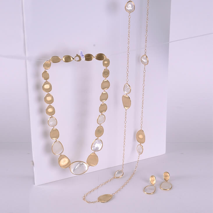 Gold and pearl jewelry set featuring a necklace, chain, and earrings, displayed before background removal.