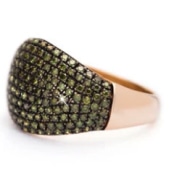 Large gold ring adorned with a pattern of black gemstones, showcasing intricate design and shine.