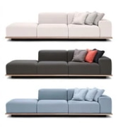 Set of three modular sofas in white, charcoal gray, and light blue, each styled with matching accent cushions.