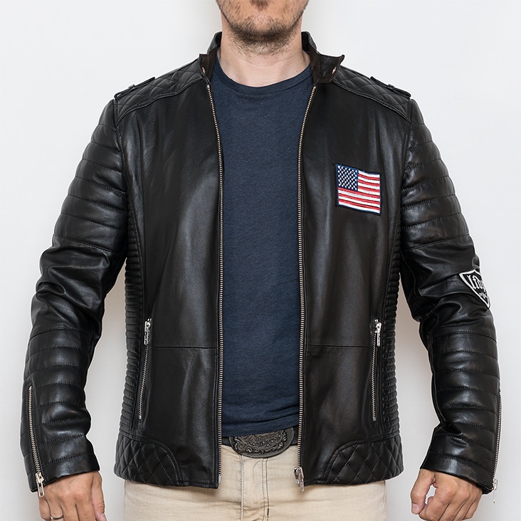 Men’s black leather jacket with quilted details and an American flag patch, displayed before ghost mannequin edit.