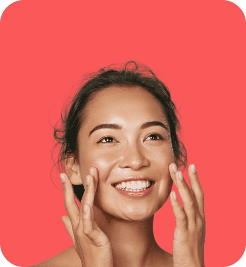 Smiling skincare model touching her face on a bright red background with clean background removal for beauty photo editing.