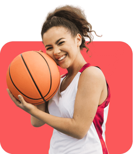 Smiling female basketball player holding a basketball on a red rounded background after background removal.