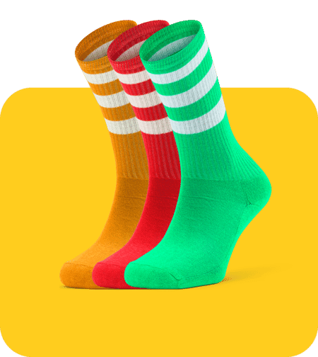 Three colorful striped socks in orange, red, and green on a yellow rounded background with clean product photo editing.