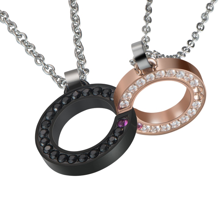 Close-up of a black and rose gold dual pendant necklace with camera reflections expertly removed.