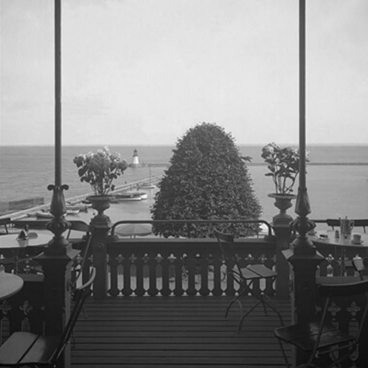 Vintage balcony overlooking a waterfront, restored with all dust, spots, and scratches removed.