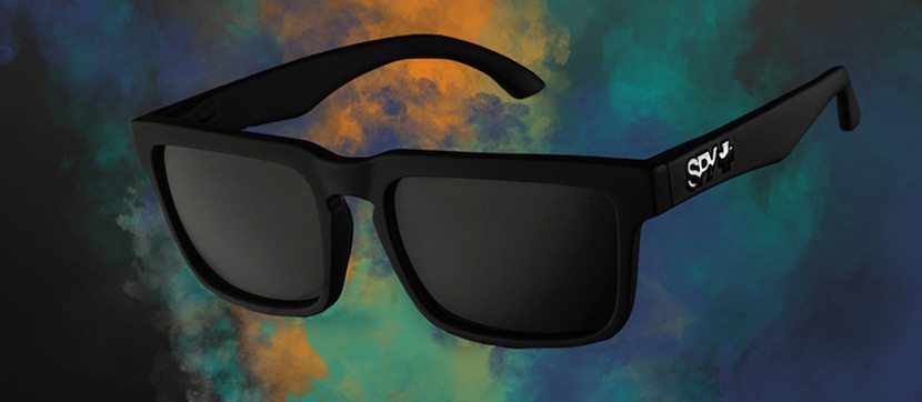 Black sunglasses with dark lenses set against a vibrant, smoky blue and orange background.
