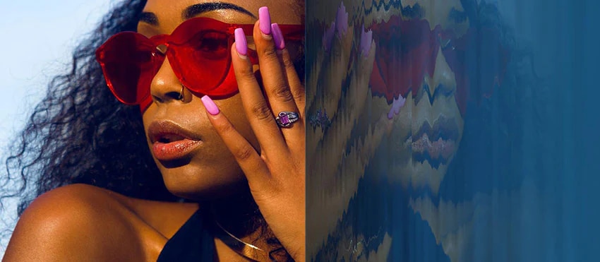 Close-up of woman in red sunglasses with pink nails, mirrored reflection effect on the right.