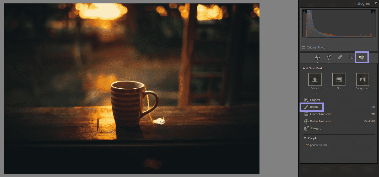 Striped tea cup on wooden surface illuminated by warm sunset light