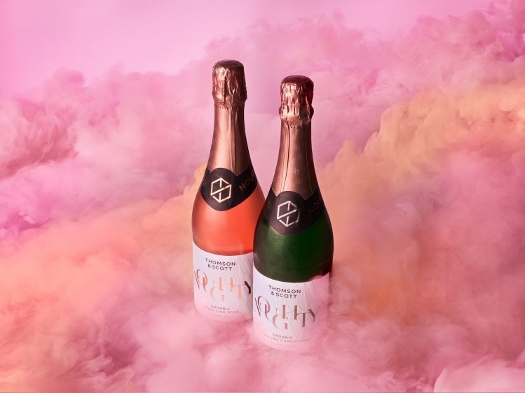 Two Thomson & Scott organic sparkling wine bottles surrounded by pink clouds