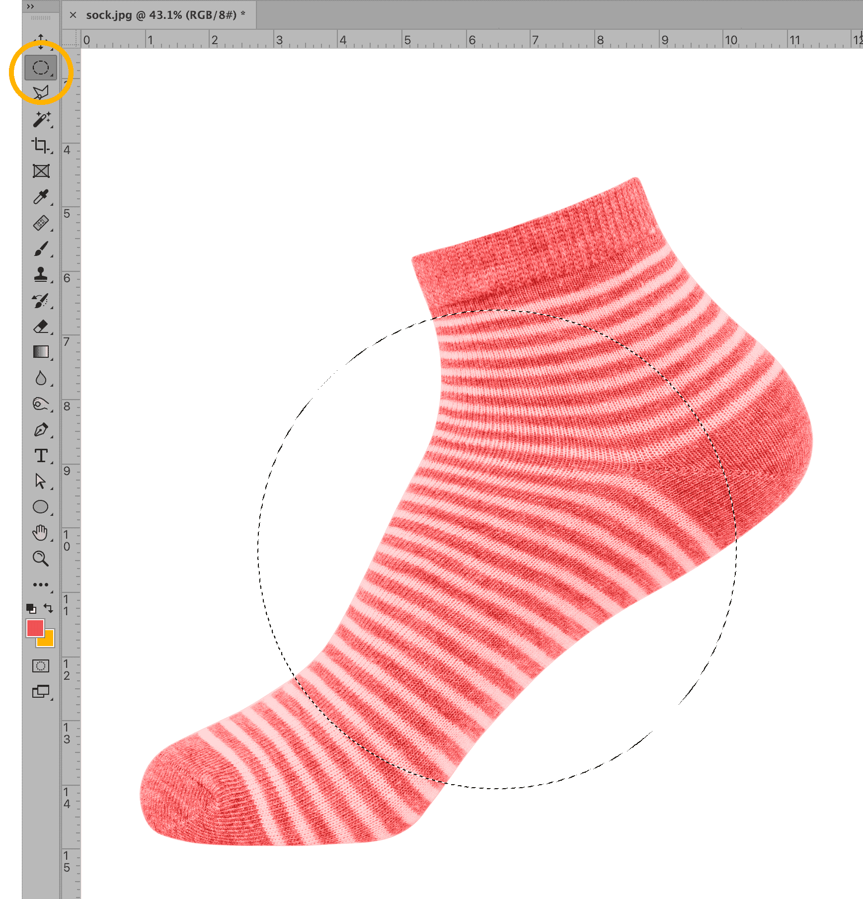 Photoshop window with Elliptical Marquee tool creating a circular selection on a red striped sock image.