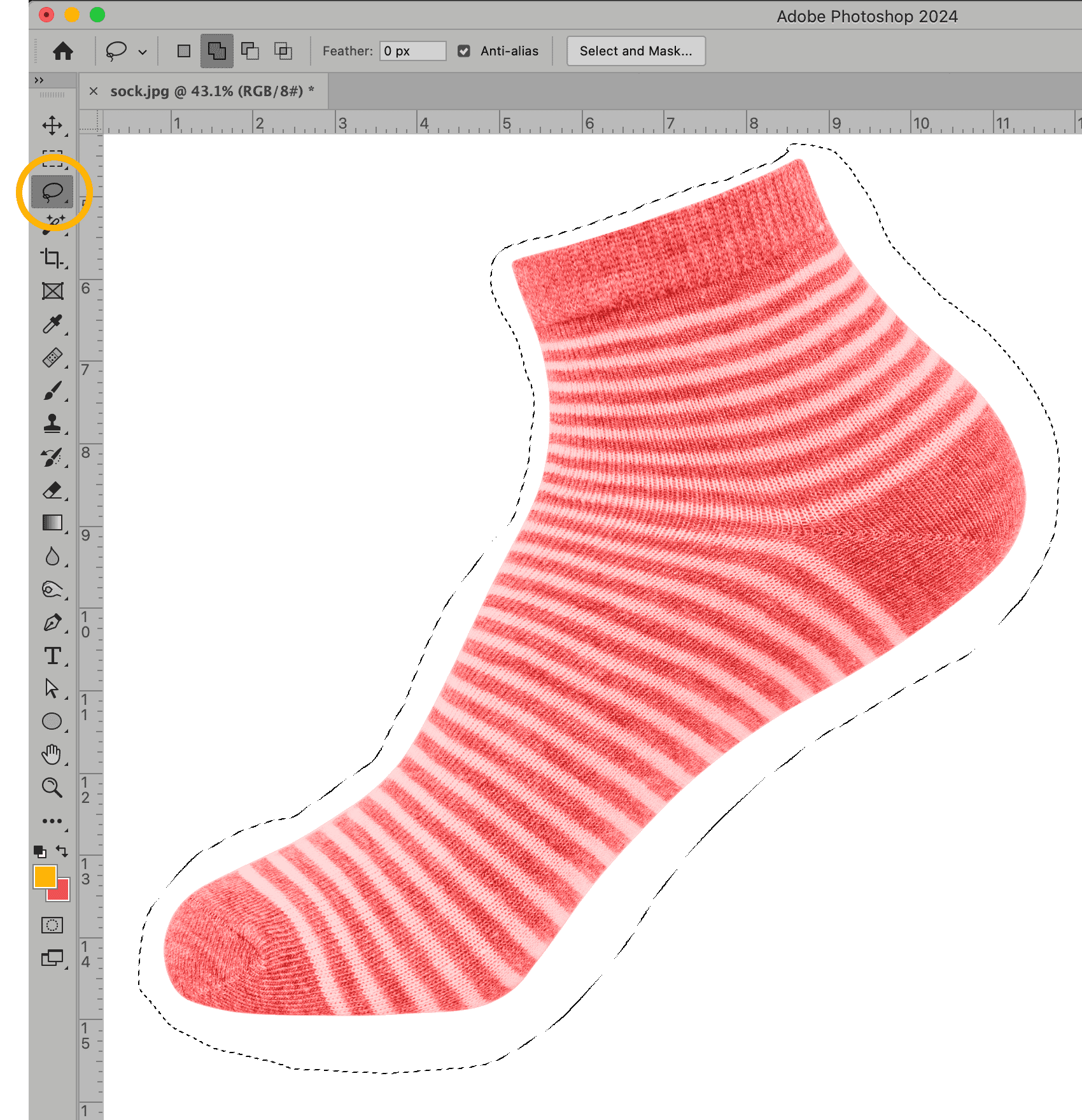 Photoshop interface using the Lasso Tool to create a selection outline around a red and white striped sock.