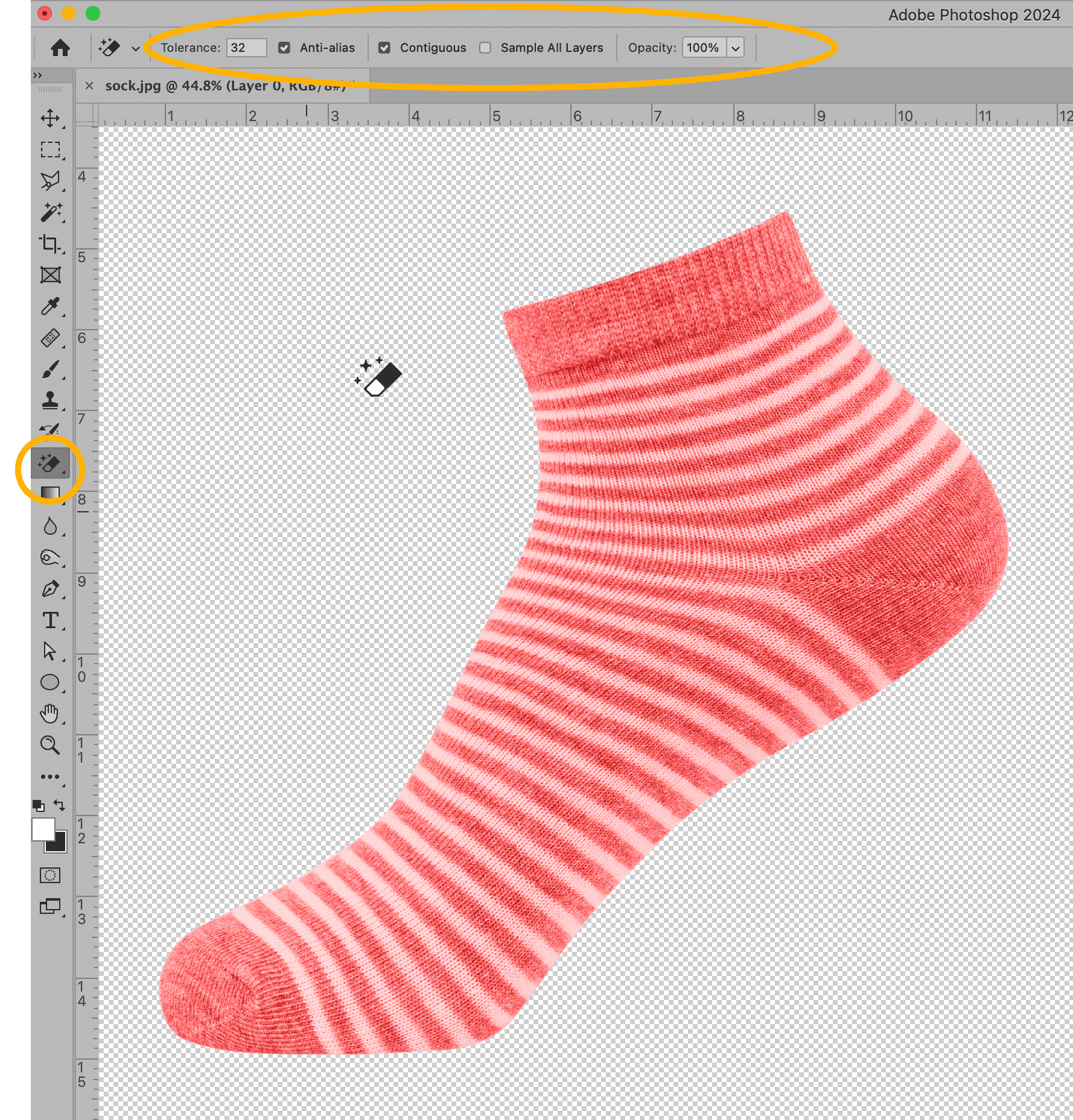 Magic eraser tool used to remove background around a striped sock in Photoshop, settings panel visible at top.