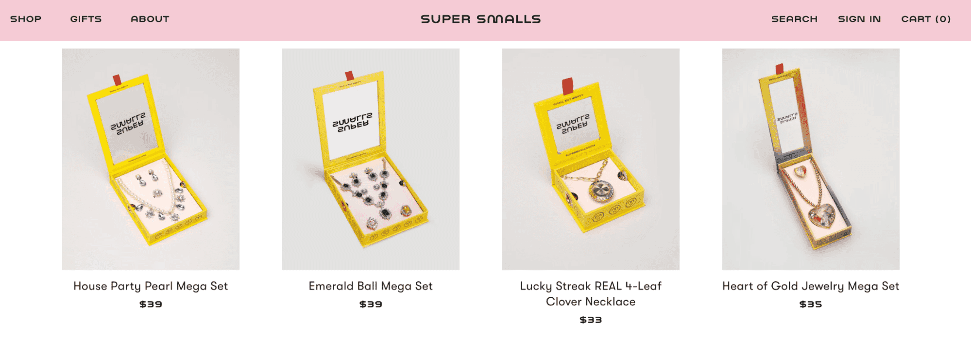 Super Smalls jewelry gift sets, including pearl, emerald, clover, and heart designs in bright yellow packaging