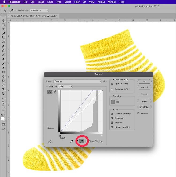 Photoshop Curves adjustment panel with black point tool highlighted, shown over an image of a yellow striped sock
