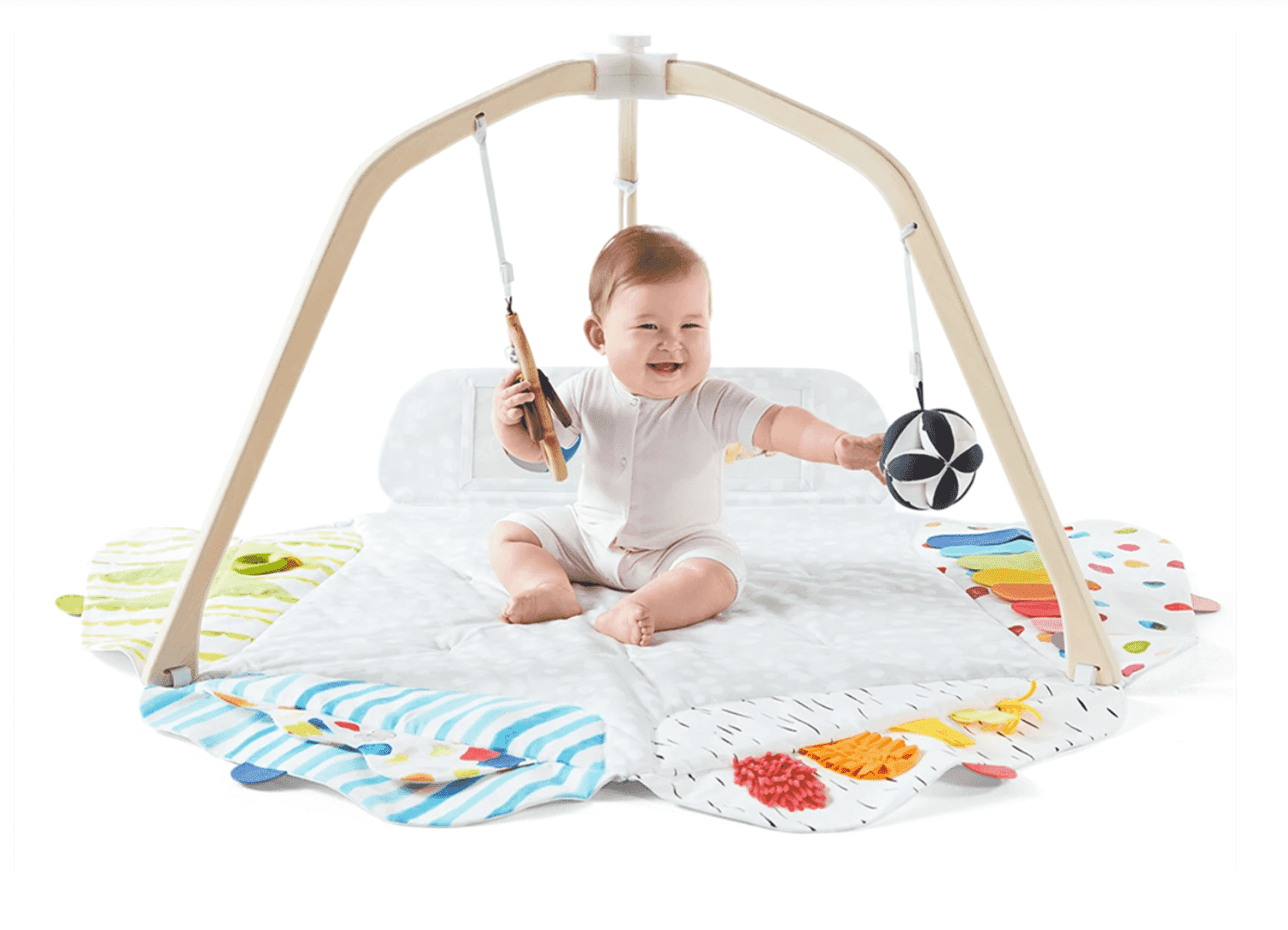 Baby playing on Lovevery play gym with colorful sensory mat and hanging toys.