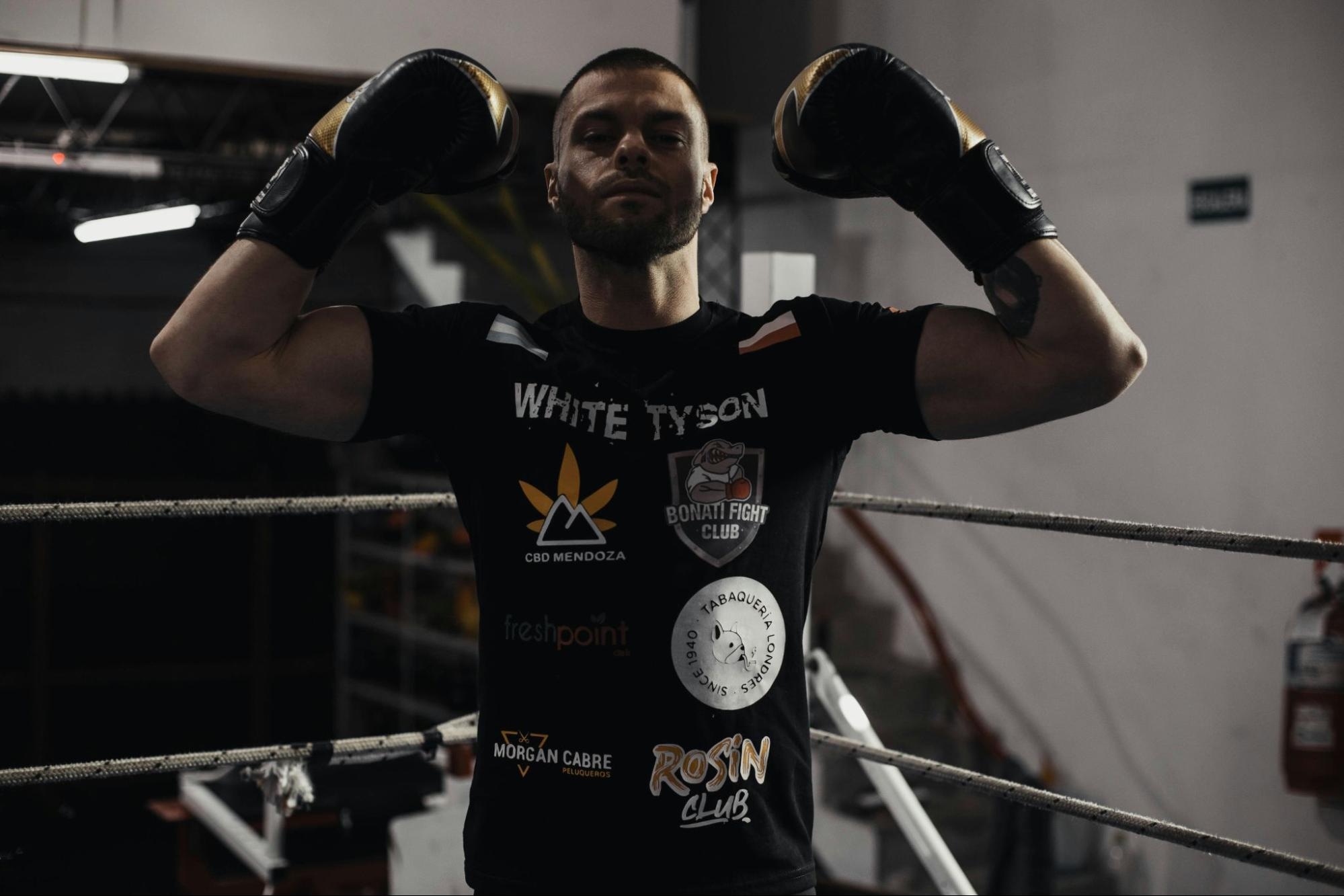 Boxer in ring with sponsor-branded t-shirt, before highlights and shadows adjustment.