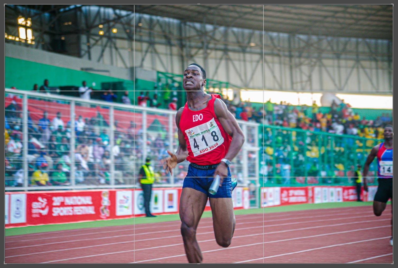 Male track athlete preparing for a sprint, showing pre-race focus and readiness.