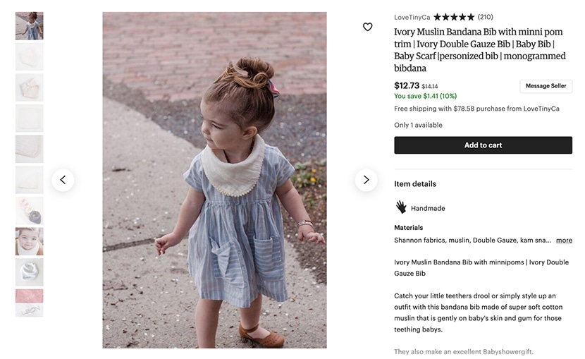 Etsy listing for a handmade ivory muslin bandana bib with pom trim, modeled by a toddler, priced at $12.73.