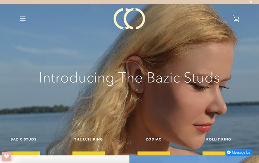 Close-up of a woman wearing Bazic Studs earrings by Claurete with scenic background.