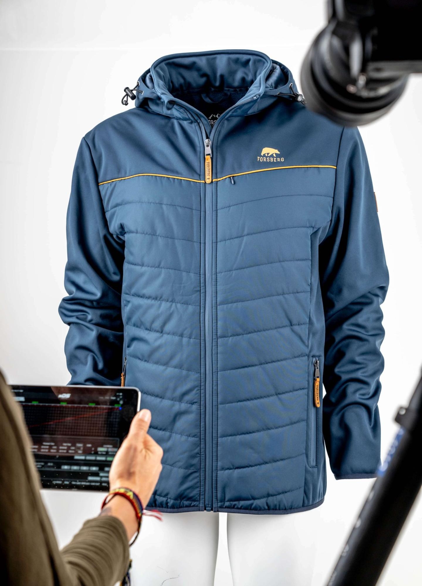Photographer capturing a blue jacket on a mannequin for ghost mannequin editing, using professional equipment.