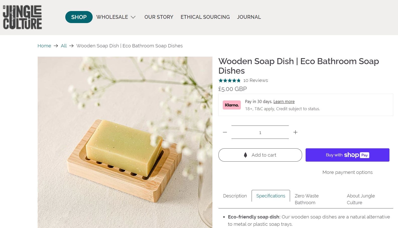 Wooden soap dish with a natural soap bar on a light background, eco-friendly bathroom accessory