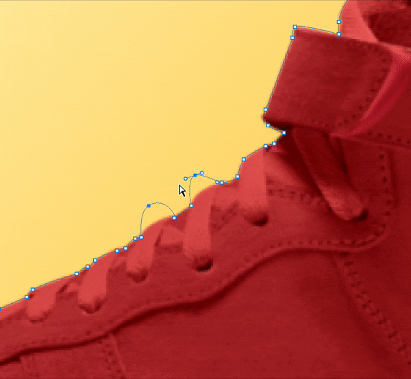 Close-up of Photoshop Pen Tool creating a clipping path around the laces of a red shoe on a yellow background.