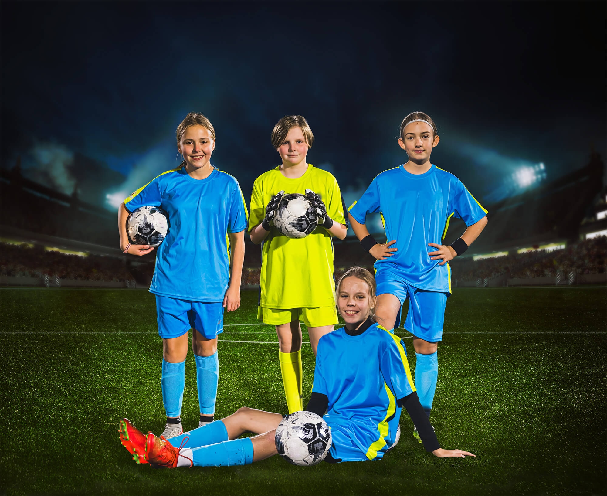 team composite photo of four girl soccer players on a lighted field at night
