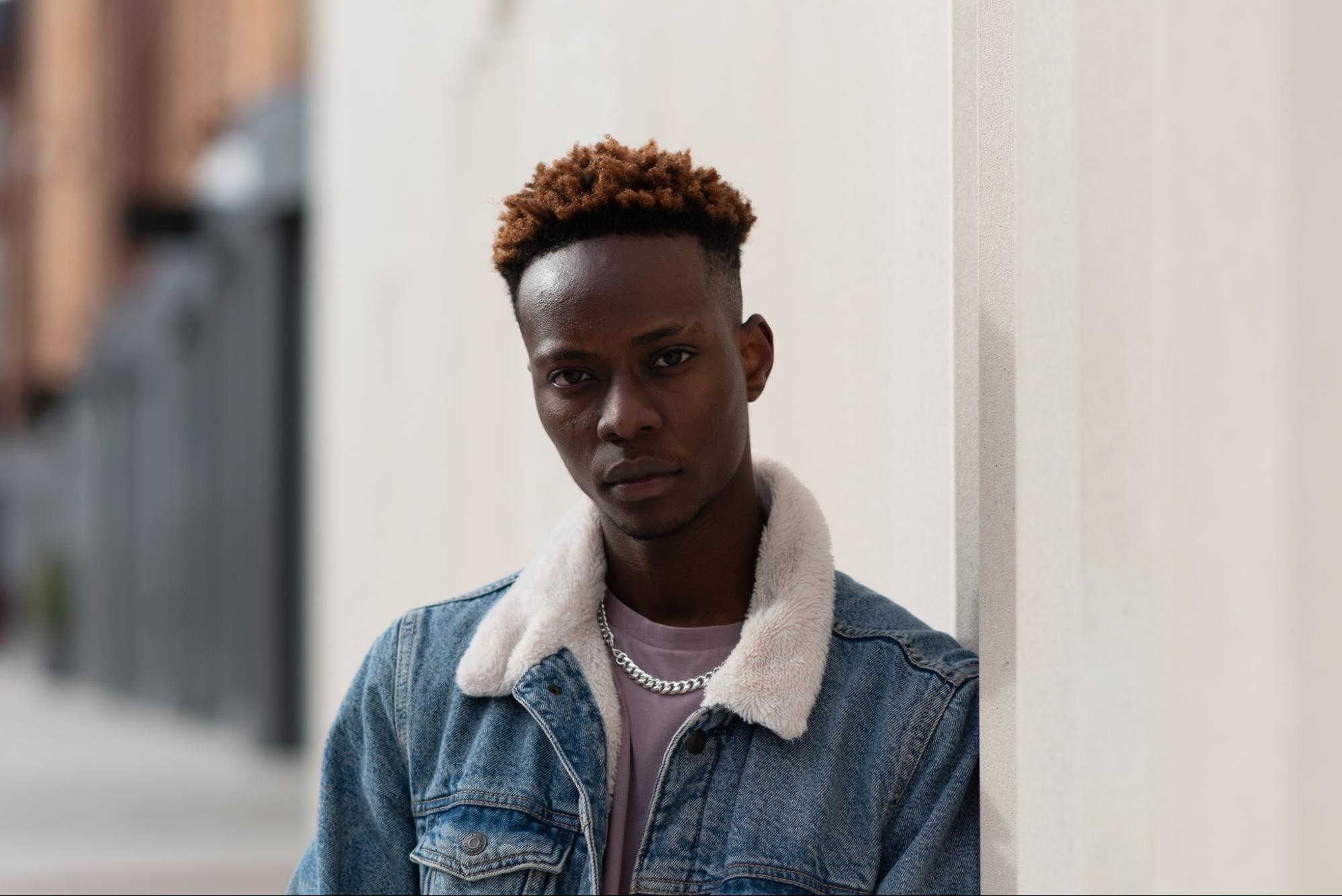 Portrait of a male model outdoors in a denim jacket after exposure and white balance adjustments.