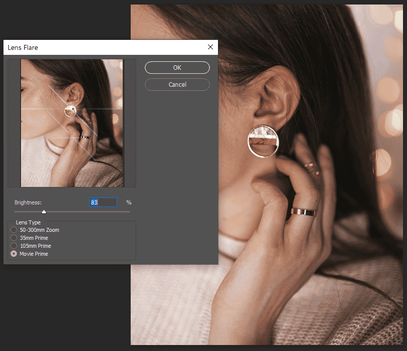 Lens flare options in Photoshop with four lens types and brightness slider applied to jewelry image