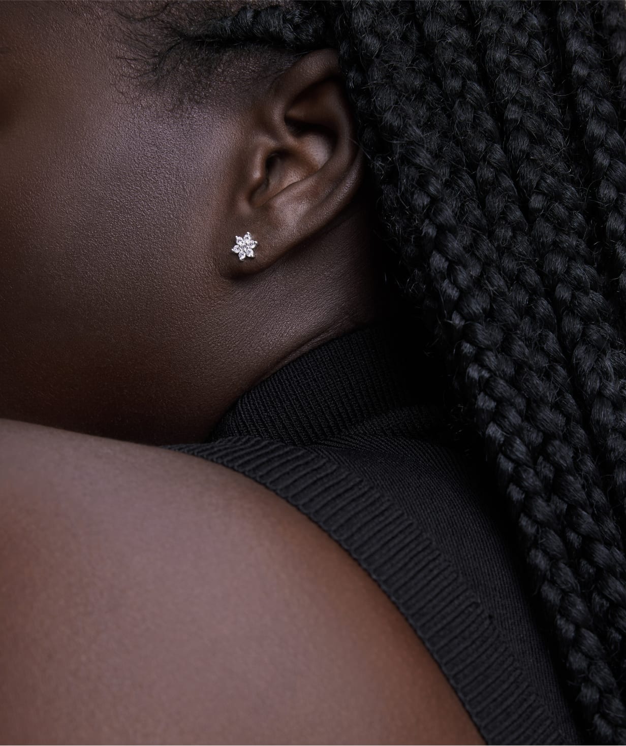 Closeup of a woman wearing a diamond stud earring, drawing attention to the jewelry piece