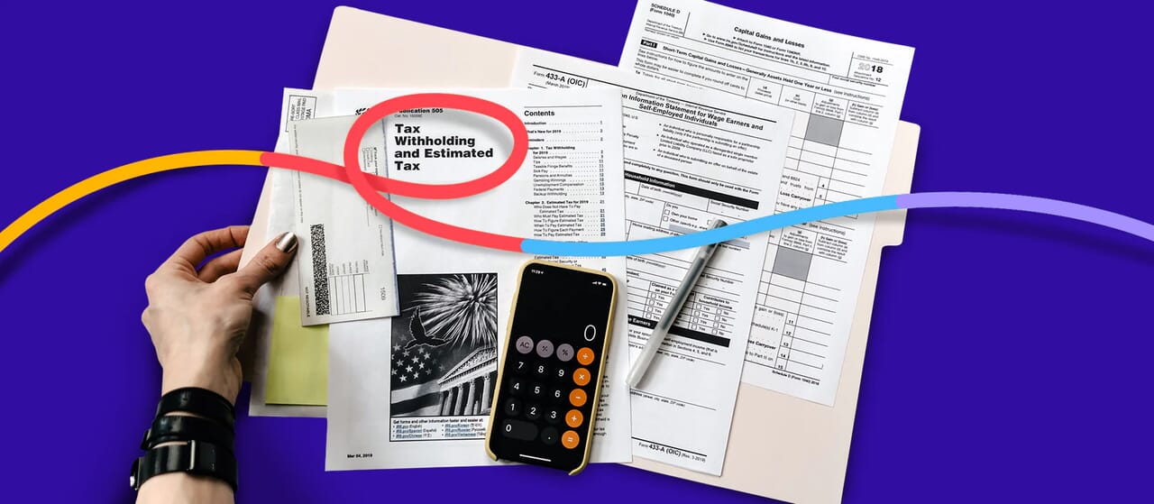 Tax documents, calculator, and filing materials organized for freelance photographer tax preparation and filing guidance.