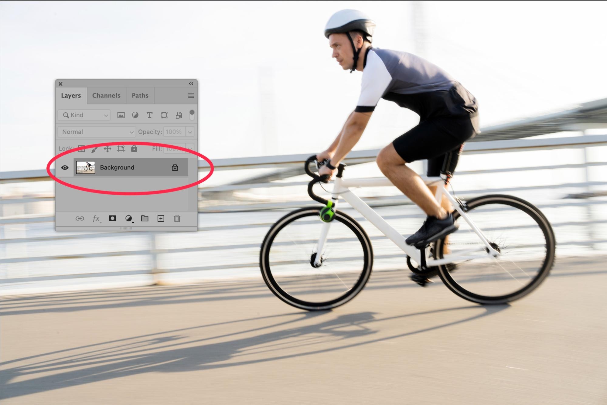 Photoshop 2025 showing the locked background layer selected in the Layers panel, displaying a motion-blurred cyclist on a bridge.