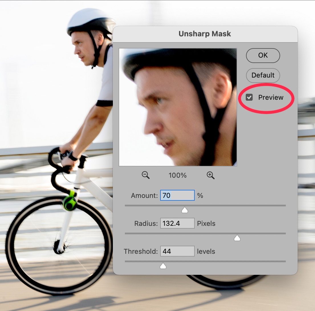 Unsharp Mask filter window in Photoshop 2025 previewing sharpening adjustments on a cyclist’s face with fine-tuned radius and threshold settings.