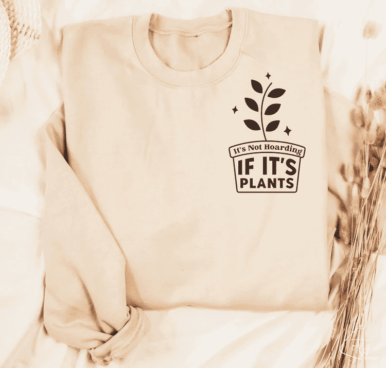 Beige sweatshirt with black text and plant graphic reading "It's Not Hoarding If It's Plants"