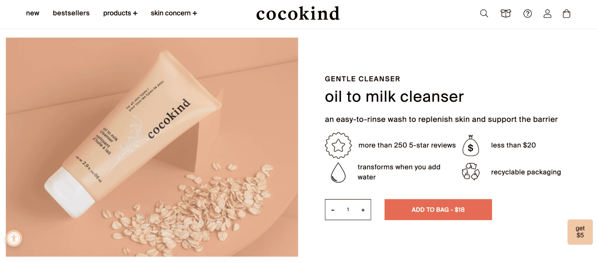 Cocokind Oil to Milk Cleanser tube displayed on beige background with scattered oats