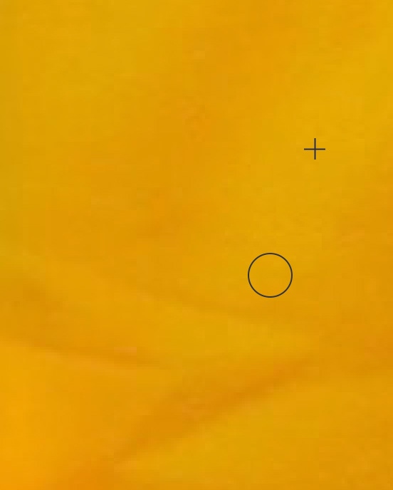 Close-up of Photoshop brush tool applying edits on yellow fabric background.