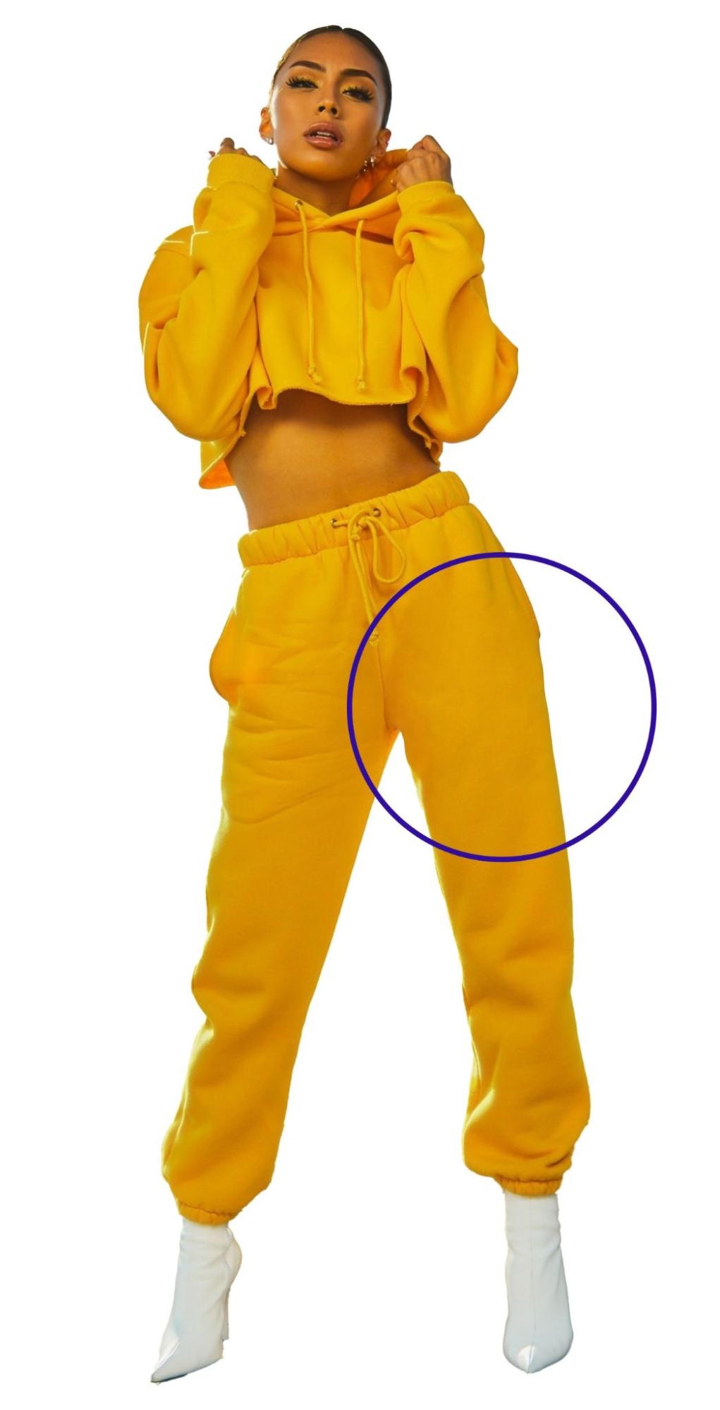 Model in yellow tracksuit with highlighted area showing Photoshop wrinkle reduction on pants