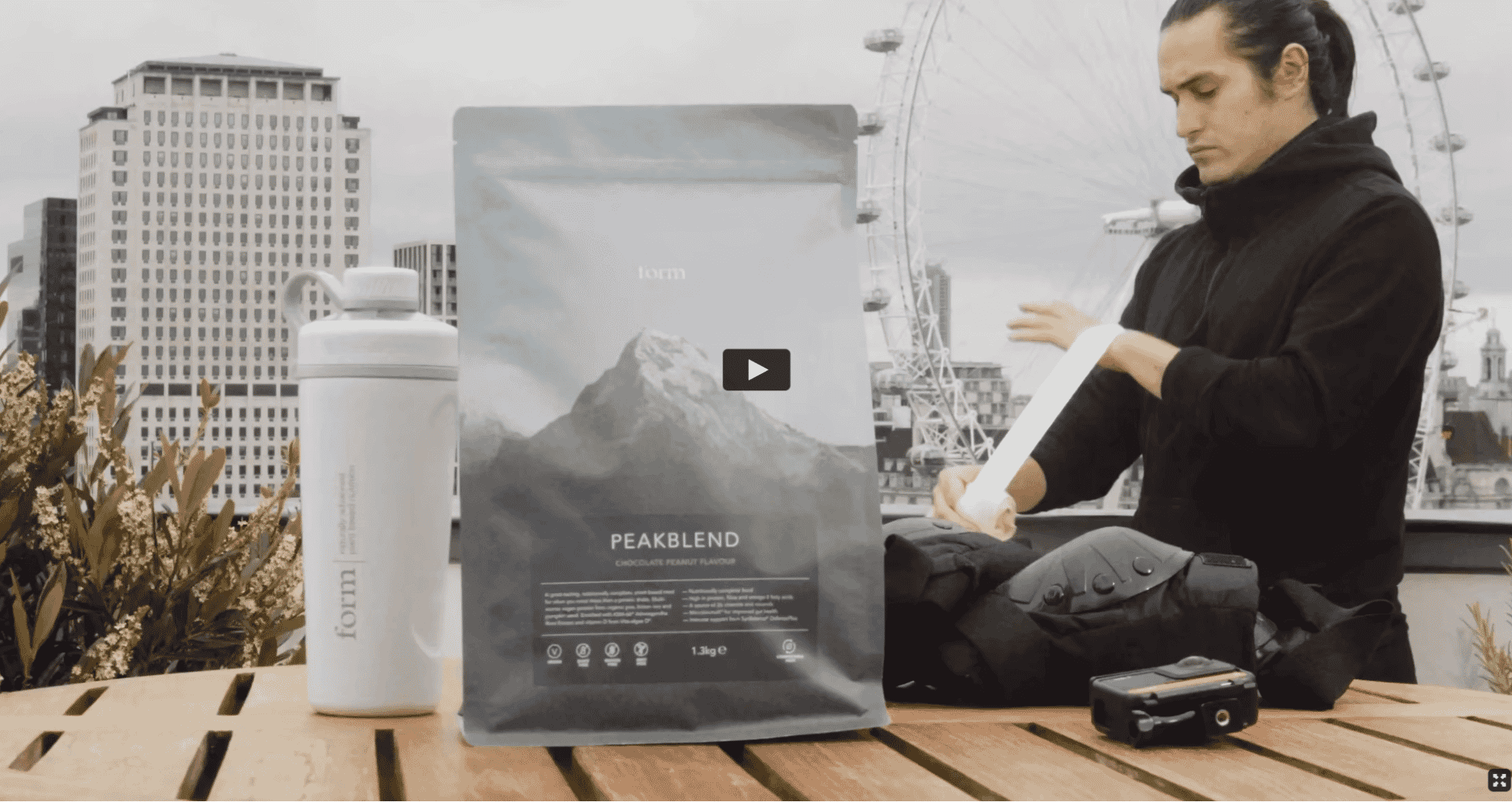 Form Nutrition Peakblend protein powder with shaker, set outdoors with city skyline backdrop