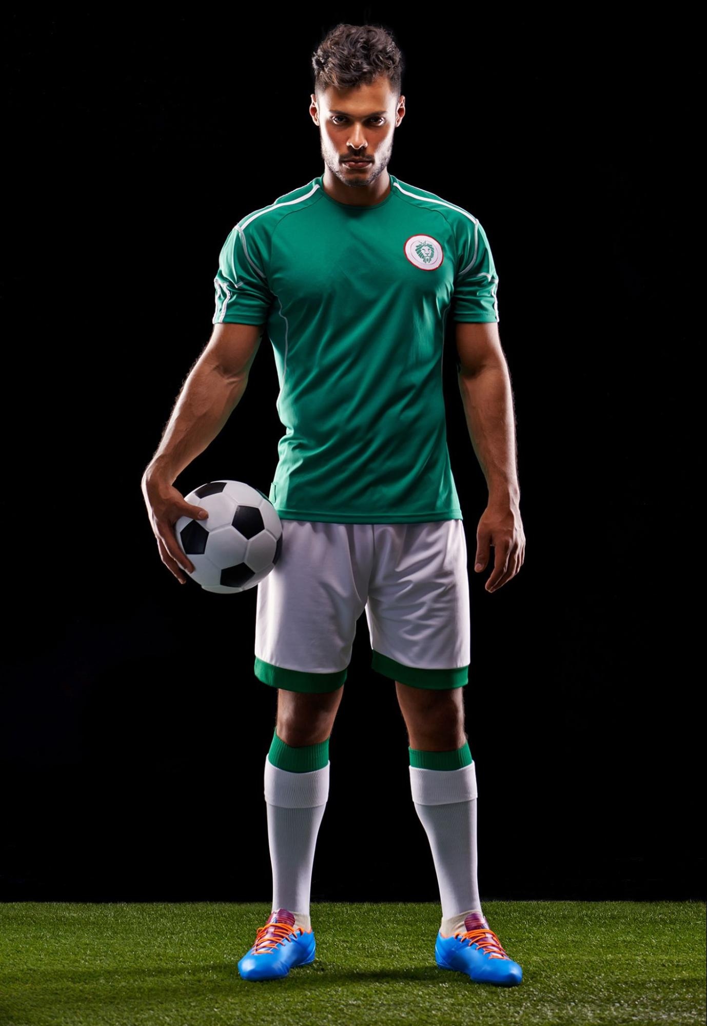 soccer player photo with black background, standing on grass