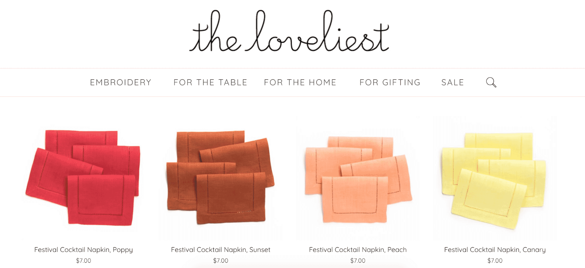 Collection of linen cocktail napkins in red, orange, peach, and yellow displayed for sale on The Loveliest website.