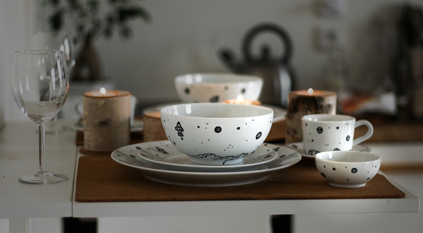 Final image of tableware setup with enhanced lighting effects, showing white dishes, cups, and candles on a table after editing.