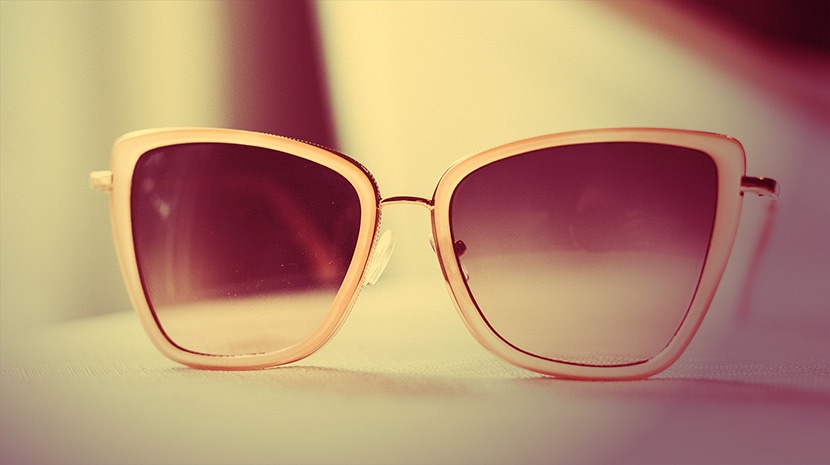Photo of sunglasses with a warm, vintage color effect applied, highlighting soft light and retro color adjustments.