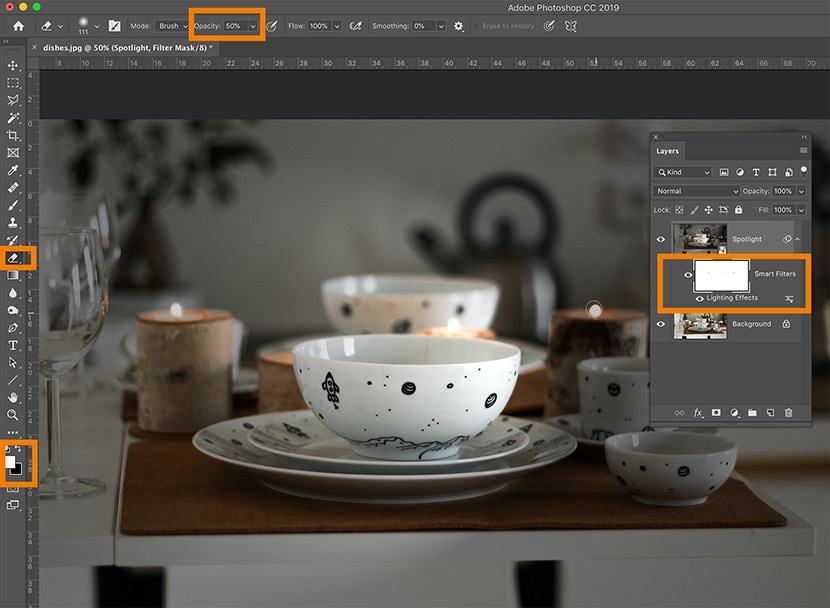 Photoshop interface with a spotlight effect mask applied to tableware, using brush opacity adjustments for refined lighting control.