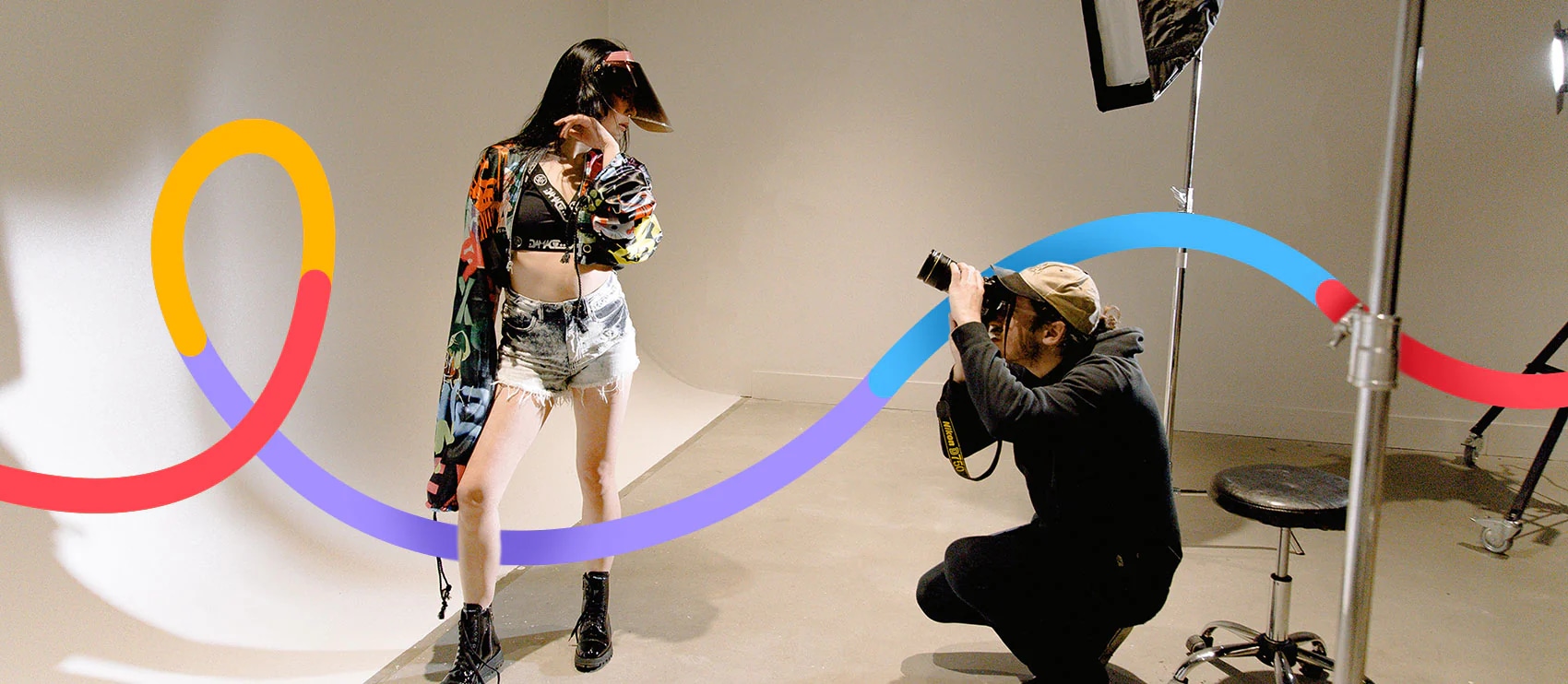 Photographer capturing model in a studio during a fashion photoshoot session.
