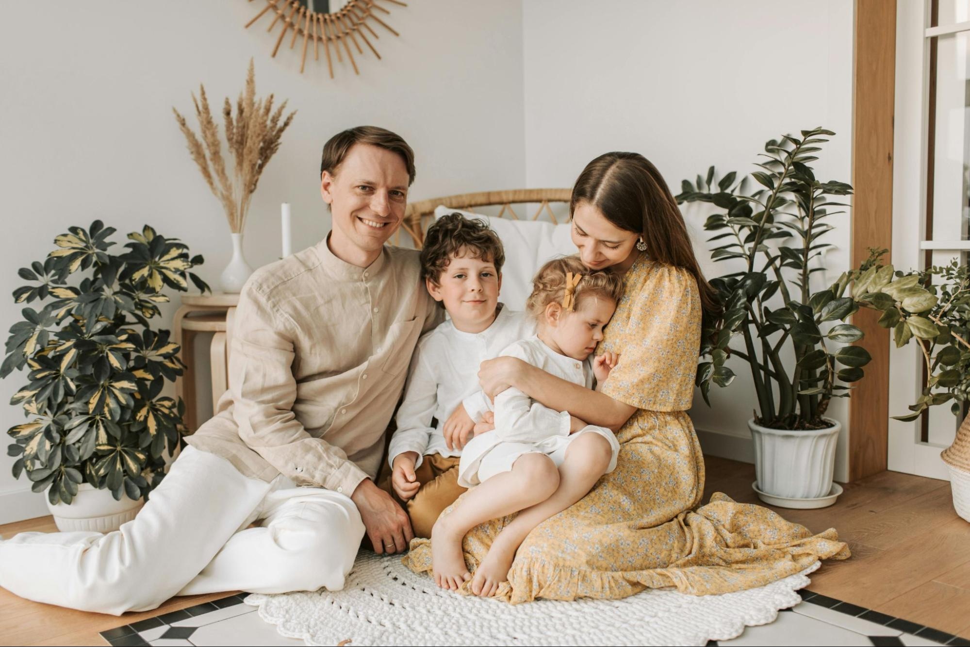 family portrait of two adults and two children in a casual home setting