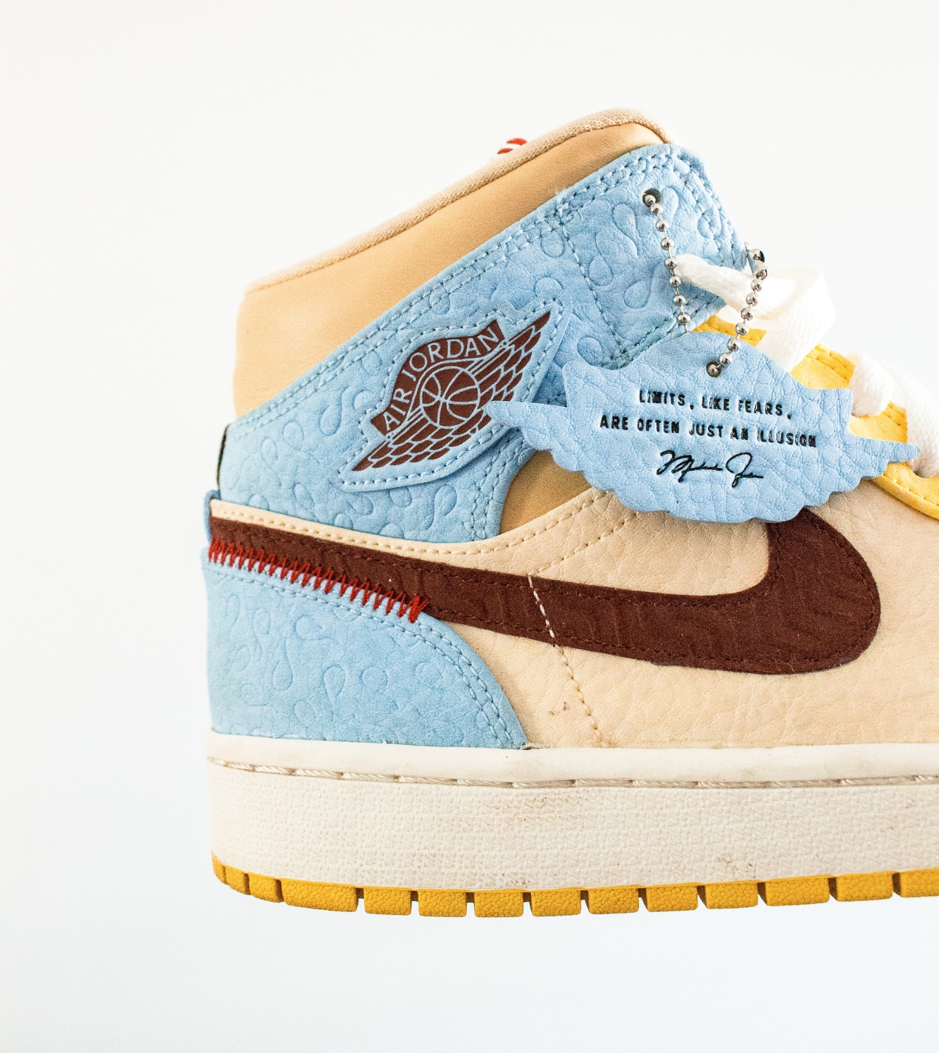 Close-up of custom Air Jordan sneaker with blue, tan, and brown details and motivational text tag