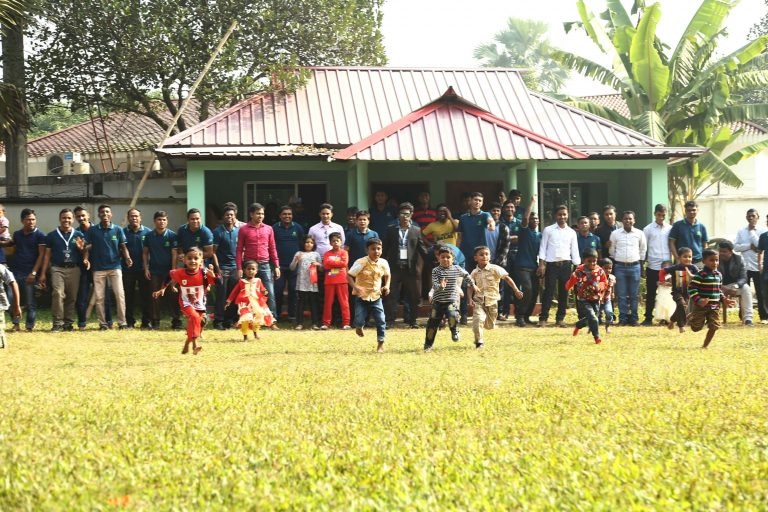 Children running in a race at Path’s family-friendly team event, with employees and family members watching in the background.
