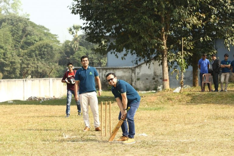 Path employees enjoying a friendly cricket game during a team-building event in an outdoor setting.