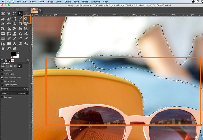 Close-up of GIMP workspace with refined selection around background object near sunglasses.